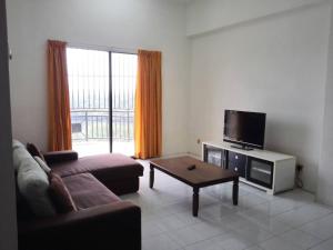 a living room with a couch and a tv at Desair Apartment By SCHT in Lumut