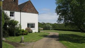 una casa blanca con un camino al lado de un campo de hierba en Pigeonwood House, en Folkestone