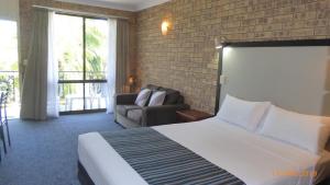 a hotel room with a bed and a couch at Tower Court Motel in Hervey Bay +51 photos