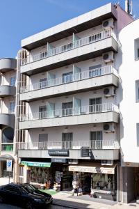 un grand bâtiment blanc avec balcon et un magasin dans l'établissement Residência S. Francisco, à Fátima