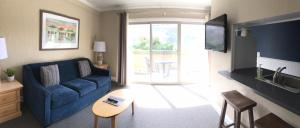 a living room with a blue couch and a table at Rio Sands Hotel in Aptos