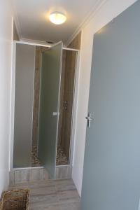a glass door in a bathroom with a shower at Modern secure beach house in Mykonos in Langebaan +22 photos