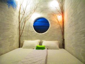 a bedroom with a bed with a round window at Phu Nam House - Resort in Phú Quốc