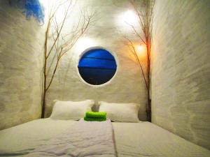 a bedroom with a bed with a round window at Phu Nam House - Resort in Phú Quốc