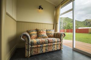 a couch sitting in a room next to a sliding glass door at Waitaki Braids in Kurow