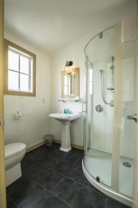 a bathroom with a shower and a sink and a toilet at Waitaki Braids in Kurow