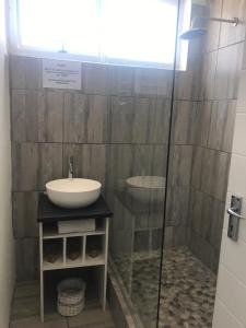 y baño con lavabo y ducha acristalada. en Modern rooms available close to the beach in Humewood, en Port Elizabeth