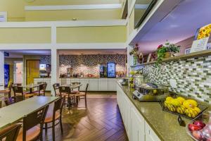 a kitchen with a counter and tables and chairs at Best Western Lakewinds in Ludington