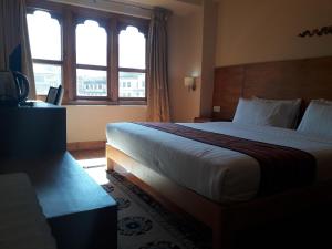 ein Hotelzimmer mit einem großen Bett und einem Fenster in der Unterkunft Gakyil Thimphu in Thimphu