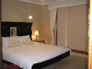 
a hotel room with a bed and a dresser at Hill Top Country Guest House in Lovedale
