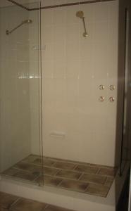 a shower with a glass door in a bathroom at Hill Top Country Guest House in Lovedale