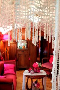 una habitación con una cortina blanca y una mesa con flores en Roulottes du Rouard, en Camiers