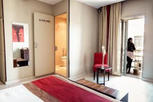 Habitación con alfombra roja y silla roja en Le Grand Mellis Hôtel & Spa, en Antananarivo