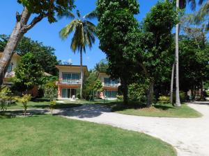 een huis met palmbomen ervoor bij Z-Touch Lipe Island Resort in Ko Lipe