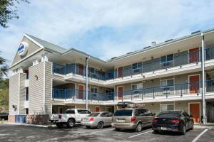 un bâtiment avec des voitures garées dans un parking dans l'établissement Suburban Studios Lakeland North I-4, à Lakeland