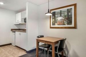 Il comprend une petite cuisine avec une table et des chaises en bois. dans l'établissement Suburban Studios Lakeland North I-4, à Lakeland