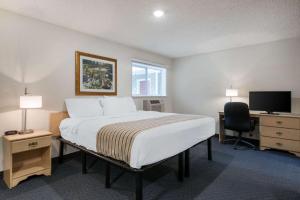 a bedroom with a bed and a desk and a television at Suburban Studios Lakeland North I-4 in Lakeland