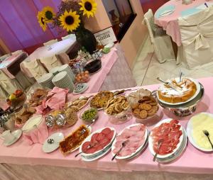 une table avec une table rose et de la nourriture dans l'établissement Hotel Ariane, à Thiene
