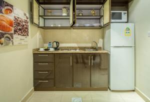 a kitchen with a refrigerator and a sink at Al Muhaidb Al Takhassosi Abaqrino in Riyadh +17 photos