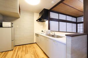 a kitchen with a sink and a refrigerator at TAMACO in Kanazawa in Kanazawa