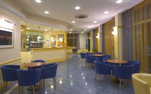 a restaurant with wooden tables and blue chairs at Hotel Sydney in San Benedetto del Tronto