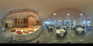 a restaurant with tables and chairs and a display of food at Hotel Sydney in San Benedetto del Tronto
