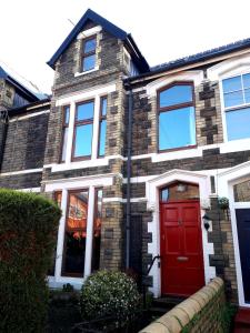 a brick house with a red door at Tŷ Selah, Rugby Ave, Neath in Neath