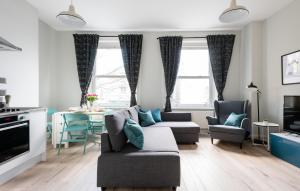 un soggiorno con divano, sedie e tavolo di The Love Walk Apartments a Londra
