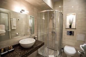 uma casa de banho com um lavatório, um chuveiro e um WC. em Spa Hotel Armira em Starozagorski Bani