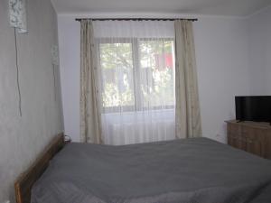 sypialnia z łóżkiem i oknem w obiekcie Agropensiunea Maris w mieście Feleacu