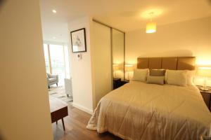 a bedroom with a bed and a chair and a window at Berkshire House in Maidenhead