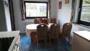 uma mesa de jantar com quatro cadeiras e um vaso de flores em Blumenstein Ferienhaus em Kall