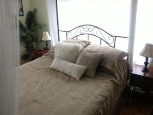 ein Bett mit Kissen darauf im Schlafzimmer in der Unterkunft Gîte Maison Parc Delormier in Trois-Rivières
