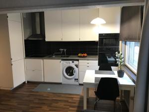 a kitchen with white cabinets and a washing machine at Apartment in Turku center in Turku