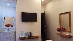 a room with a flat screen tv on a wall at Villa Boua Thong Hotel in Luang Prabang
