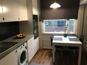 a kitchen with a washing machine and a table at Apartment in Turku center in Turku