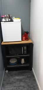 a microwave sitting on top of a shelf in a room at Etape forêt Fontainebleau climb & randonnées in Arbonne