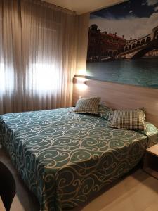 una camera da letto con un letto e un dipinto sul muro di Hotel Altieri a Favaro Veneto