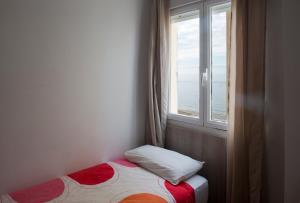 Cama pequeña en habitación con ventana en Casita Coqueta Free Parking, en Cádiz