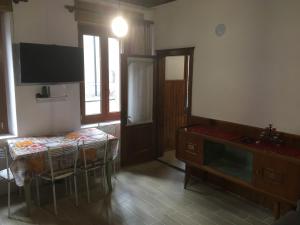 een kamer met een tafel en een televisie en een tafel en stoelen bij Antica Casa Nella in Venas