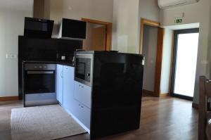 a kitchen with a stove and a dishwasher at Casa dos Avós by Eira dos Canastros in Espindelo