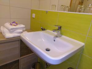 ein Badezimmer mit einem Waschbecken und Handtüchern auf der Theke in der Unterkunft Ilka´s kleine Harmonie in Leipzig + 17 Fotos