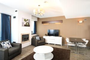 a living room with a couch and a tv at Silver Mountain Apartment 26 in Poiana Brasov