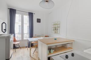 eine Küche mit einem Tisch und einem Esszimmer in der Unterkunft Lovely Parisian Flat - Louvre rue St Honoré in Paris