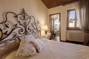 1 dormitorio con 1 cama con cabecero grande y ventana en B&B L'Orologio, en Signa
