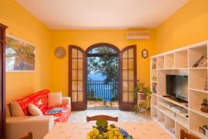 a living room with yellow walls and a table at Casa Marea in Conca dei Marini