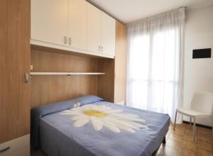 een slaapkamer met een blauw bed met een bloem erop bij Condominio Pleione in Bibione