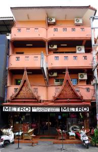 duży pomarańczowy budynek z znakiem przed nim w obiekcie Metro Apartments w mieście Pattaya Central