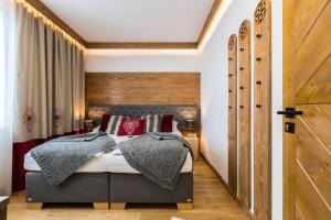 a bedroom with a bed with red pillows at Apartamenty Tradycja in Zakopane