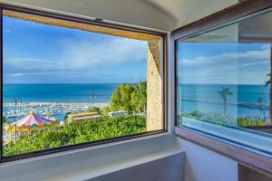 a window with a view of the ocean at Le Maestranze Deluxe Rooms in Sciacca